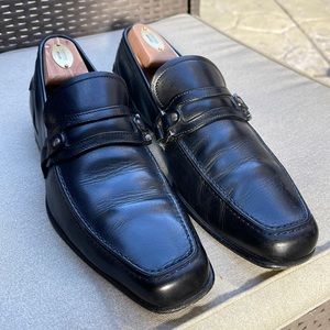 Black leather Salvatore Ferragamo loafers. Right shoe missing one buckle